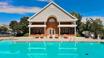 A house with a pool in front of it.
